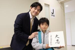 直筆の色紙をもらった子どもと金井六段